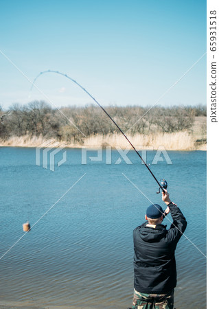 Feeder fishing. Male fisherman fishing at sun day Feeder fishing. Male fisherman fishing at sun day 65931518