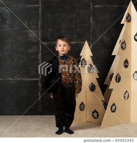 the little boy next to decorative Christmas trees 65933343