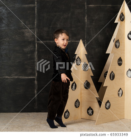 the little boy next to decorative Christmas trees 65933349