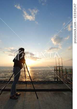 Photographer shooting the sunset over the Ariake Sea Photographer shooting the sunset over the Ariake Sea 65934147