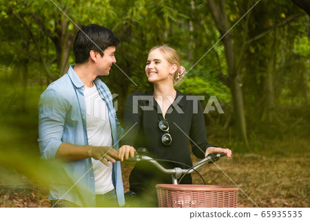 Happy young couple going for a bike ride on a Happy young couple going for a bike ride on a 65935535