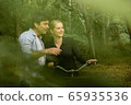 Young couple going for a bike ride in the green 65935536