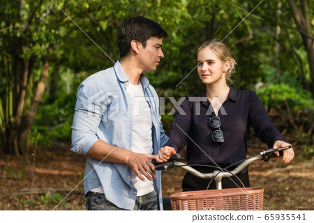 Happy young couple going for a bike ride on a Happy young couple going for a bike ride on a 65935541