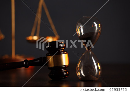 Judge's gavel, scales of justice and hourglass on wooden table. Law concept 65935753