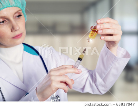 Doctor holding a coronavirus vaccine ampoule, Covid-19 vaccine. 65937047