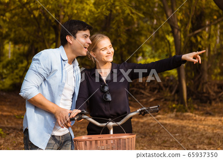 Romantic young couple in love and going for a bike 65937350