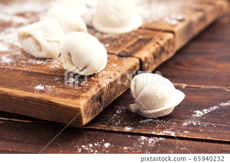 Raw homemade handmade pelmeni (dumplings) with meat on wood 65940232