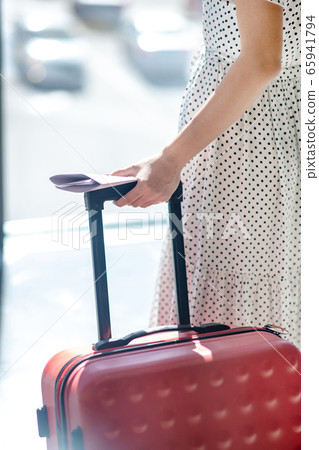 Close-up of female hands holding red suitcase handle Close-up of female hands holding red suitcase handle 65941794