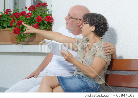 senior couple with a tablet, outside 65944102