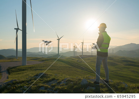 Technician Engineer in Wind Turbine Power Generator Station launches a drone for visual control of generators 65945295