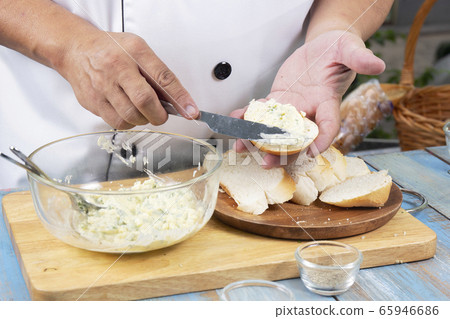 Chef spread garlic butter on slice bread Chef spread garlic butter on slice bread 65946686