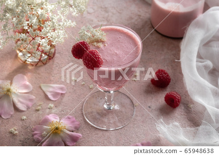 A glass of goat kefir with blended raspberries A glass of goat kefir with blended raspberries 65948638