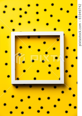 Black paper stars and white frame on yellow background 65949742