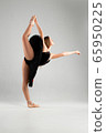 Girl in a black ballet dress. Ballerina in a dark ballet tutu on a light background. The young ballerina is warming up 65950225