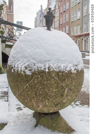 Stone ball covered by snow in old town of Gdansk in Poland. Stone ball covered by snow in old town of Gdansk in Poland. 65950489