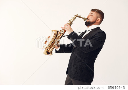 Man in black suit standing with a saxophone Man in black suit standing with a saxophone 65950643