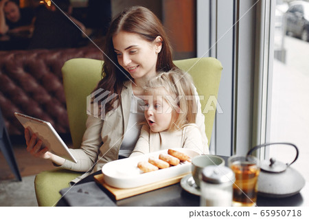 Mother with daughter sitting in a cafe Mother with daughter sitting in a cafe 65950718
