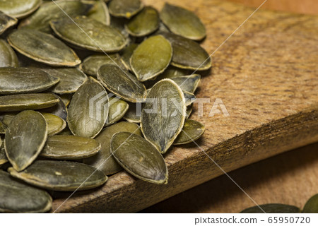 Pumpkin seeds in a pile wide angle macro sliding Pumpkin seeds in a pile wide angle macro sliding 65950720