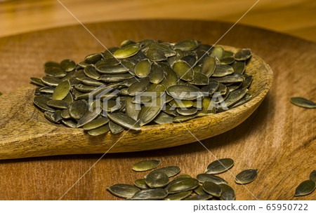 Pumpkin seeds in a pile wide angle macro sliding Pumpkin seeds in a pile wide angle macro sliding 65950722