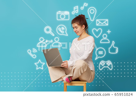 Woman is siting in lotus position on a chair with a laptop. Woman is siting in lotus position on a chair with a laptop. 65951024