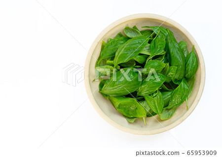 Bowl of basil leaves on white background. 65953909