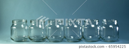 Horizontal row of transparent jars on a blue background with a wide baner. Horizontal row of transparent jars on a blue background with a wide baner. 65954225