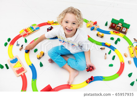 Child with toy train. Kids wooden railway. 65957935