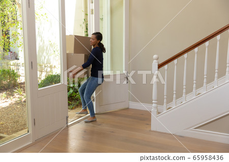 Mixed race woman arriving at her new home 65958436