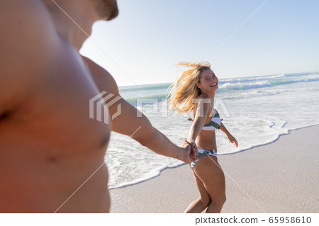 Caucasian couple walking at the beach 65958610