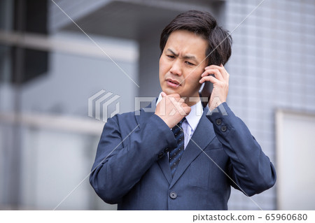 打電話給智能手機時遇到麻煩的商人（麻煩） 65960680