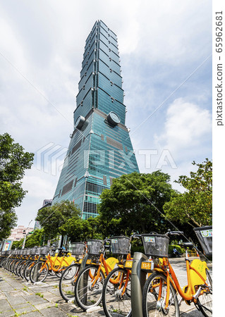 Popular bicycle parking station of the Taipei Bike Sharing System. beautiful view of Taipei 101 and orange YouBikes on the road in the center of Xinyi District. Popular bicycle parking station of the Taipei Bike Sharing System. beautiful view of Taipei 101 and orange YouBikes on the road in the center of Xinyi District. 65962681