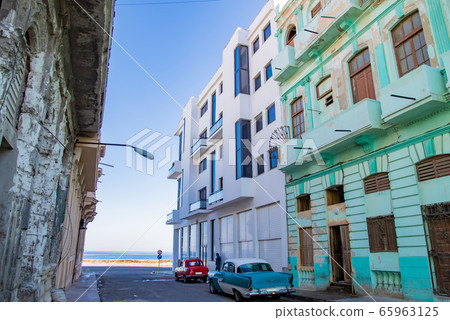 A classic car overlooking the coast of Malecon Street in Havana, Cuba 65963125