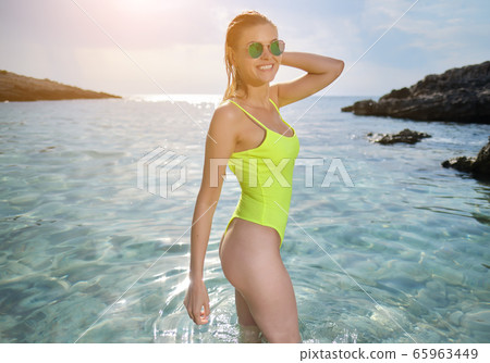 fit woman in posing on beach.  woman posing by sea 65963449