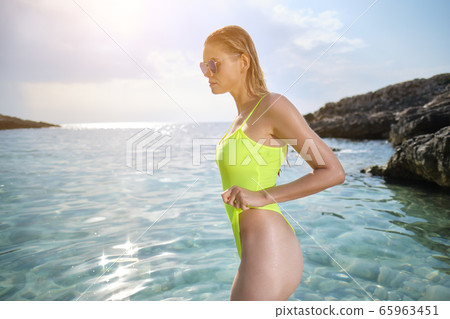 fit woman in posing on beach.  woman posing by sea 65963451