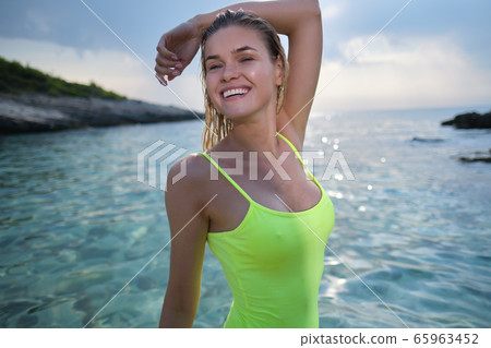 fit woman in posing on beach. woman posing by sea fit woman in posing on beach. woman posing by sea 65963452