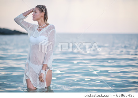 fit woman in posing on beach. Stylish look woman fit woman in posing on beach. Stylish look woman 65963453