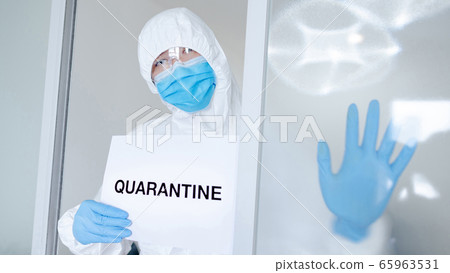 Doctor in PPE suit showing paper quarantine 65963531