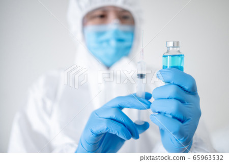Doctor in PPE suit injecting vaccine 65963532
