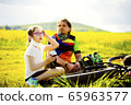 Sport and quarantine. 9 years girl ciclist with father having rest breathing without masks admist the fields in the sunny day 65963577