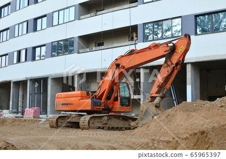 Excavator at a construction site during earthworks 65965397