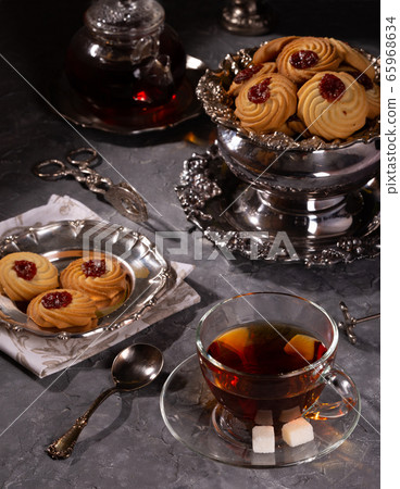 Tea and cookies in vintage utensils on a gray Tea and cookies in vintage utensils on a gray 65968634