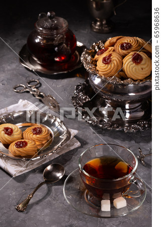 Tea and cookies in vintage utensils on a gray Tea and cookies in vintage utensils on a gray 65968636