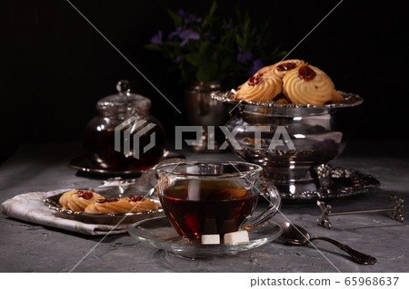 Tea and cookies in vintage utensils on a gray Tea and cookies in vintage utensils on a gray 65968637