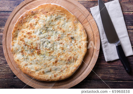 Ossetian pie with cheese and herbs (dill, parsley, scallion). Traditional Ossetian baking.  65968838