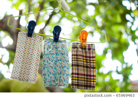 Closed up three brightly colored fabric handmade were washed and dried under the shade of the backyard. Which a beautiful bokeh. People like to use it as an extension of the mask. 65969463