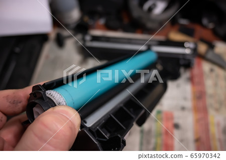 the master holds the disassembled laser printer cartridge the master holds the disassembled laser printer cartridge 65970342