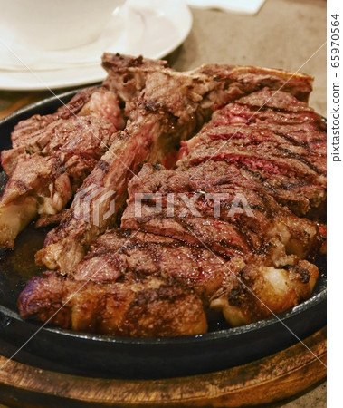 closeup prime rib steak in hot plate closeup prime rib steak in hot plate 65970564