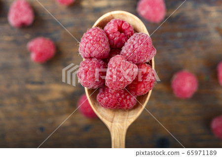 raspberries in a wooden spoon raspberries in a wooden spoon 65971189