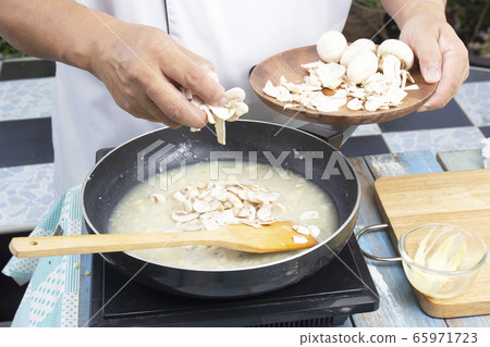 Chef pouring slice of mushroom cream soup Chef pouring slice of mushroom cream soup 65971723