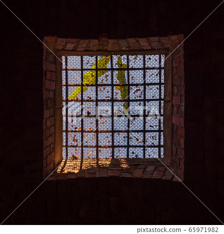 View to the sky through barred window 65971982
